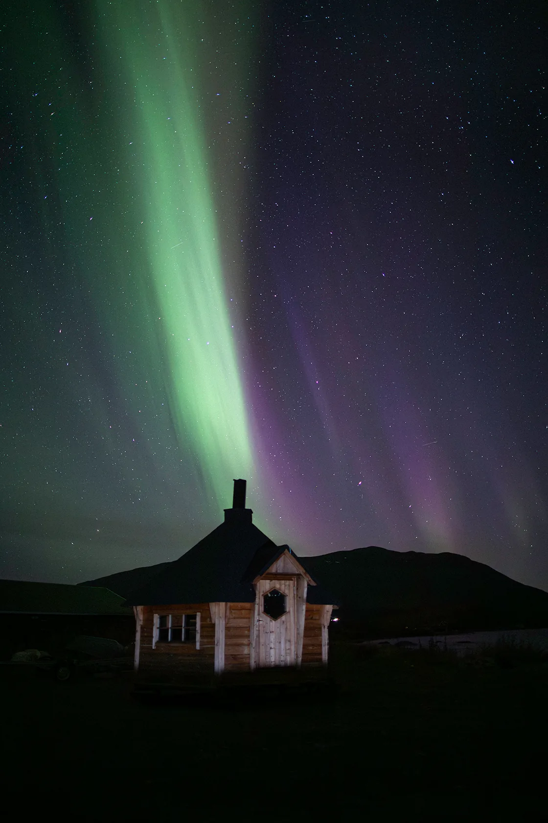 The northern lights above a snow-covered chapel outside Kiruna at night